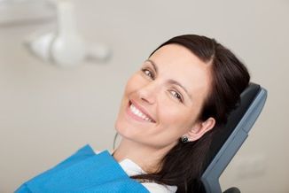 Lächelnde Patientin lässt Parodontitis behandeln 
